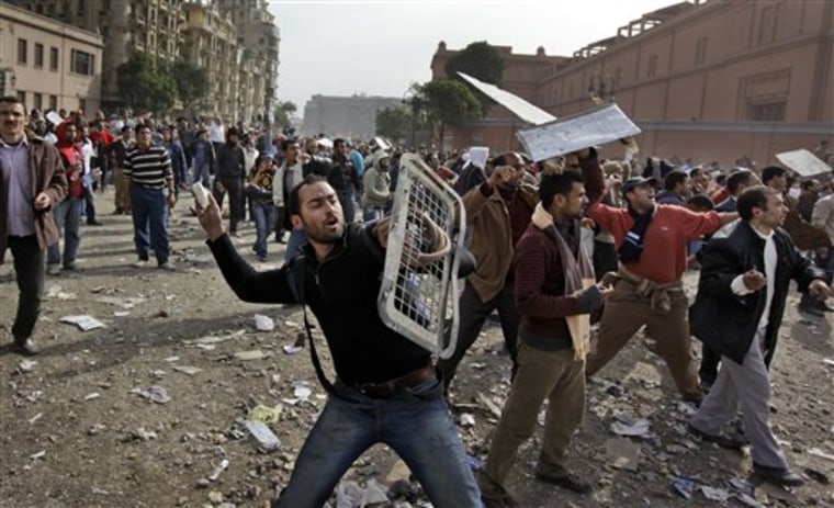 ALTERNATE CROP OF BCO162 - Anti-government protestors throw stones during clashes in Cairo, Egypt, Thursday, Feb. 3, 2011. Egypt's prime minister apologized for an attack by government supporters on protesters in a surprising show of contrition Thursday, and the government offered more concessions to try to calm the wave of demonstrations demanding the ouster of President Hosni Mubarak. (AP Photo/Ben Curtis)